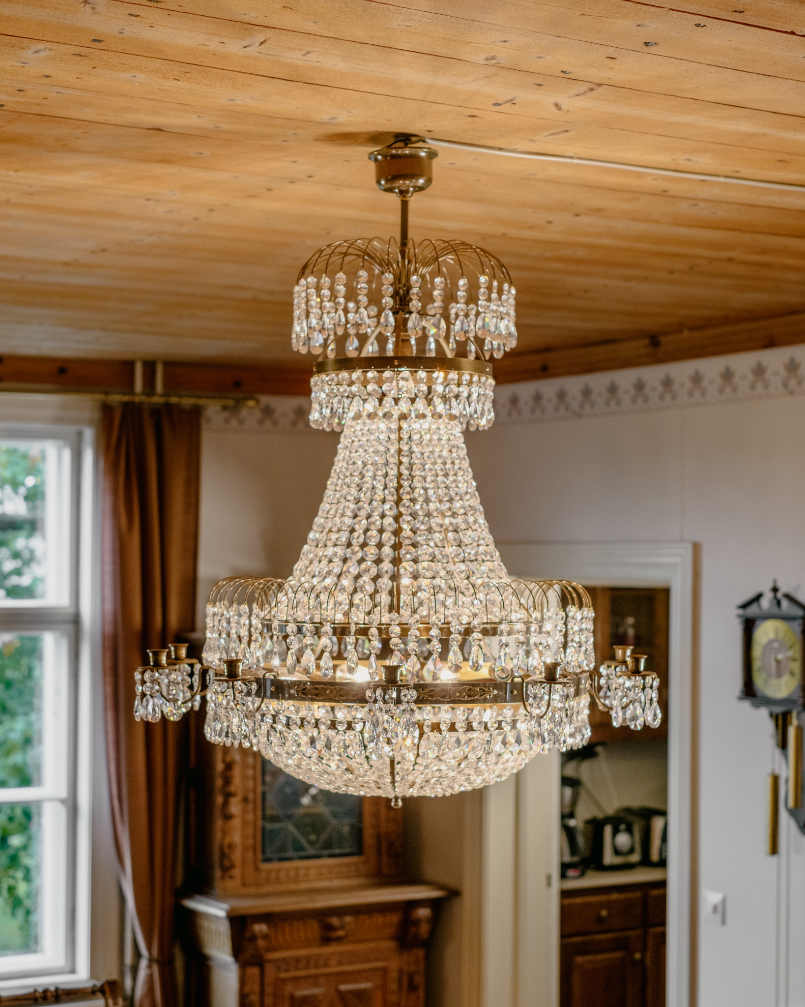 A luxury chandelier with both electric lights and candle placements. A crystal chandelier with an elegant look.
